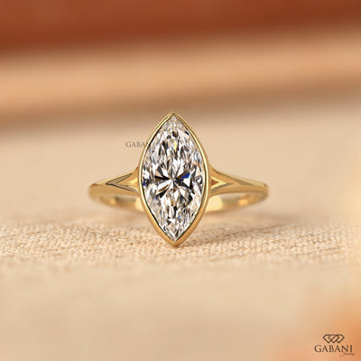 marquise cut diamond solitaire engagement ring with full bezel setting in yellow gold