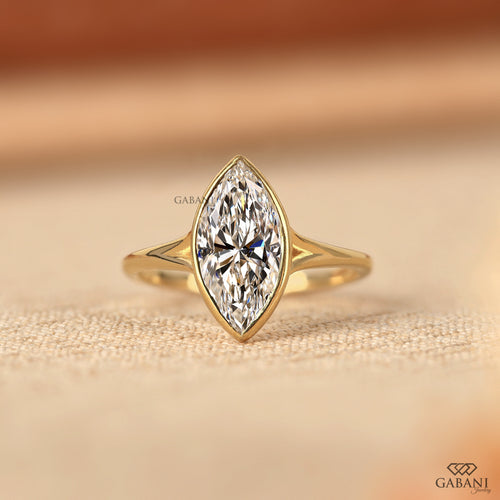 marquise cut diamond solitaire engagement ring with full bezel setting in yellow gold
