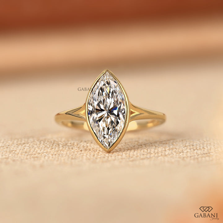 marquise cut diamond solitaire engagement ring with full bezel setting in yellow gold