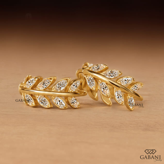 Marquise diamond leaf huggie earrings in yellow gold with a nature inspired vine design and marquise cut diamond leaves.