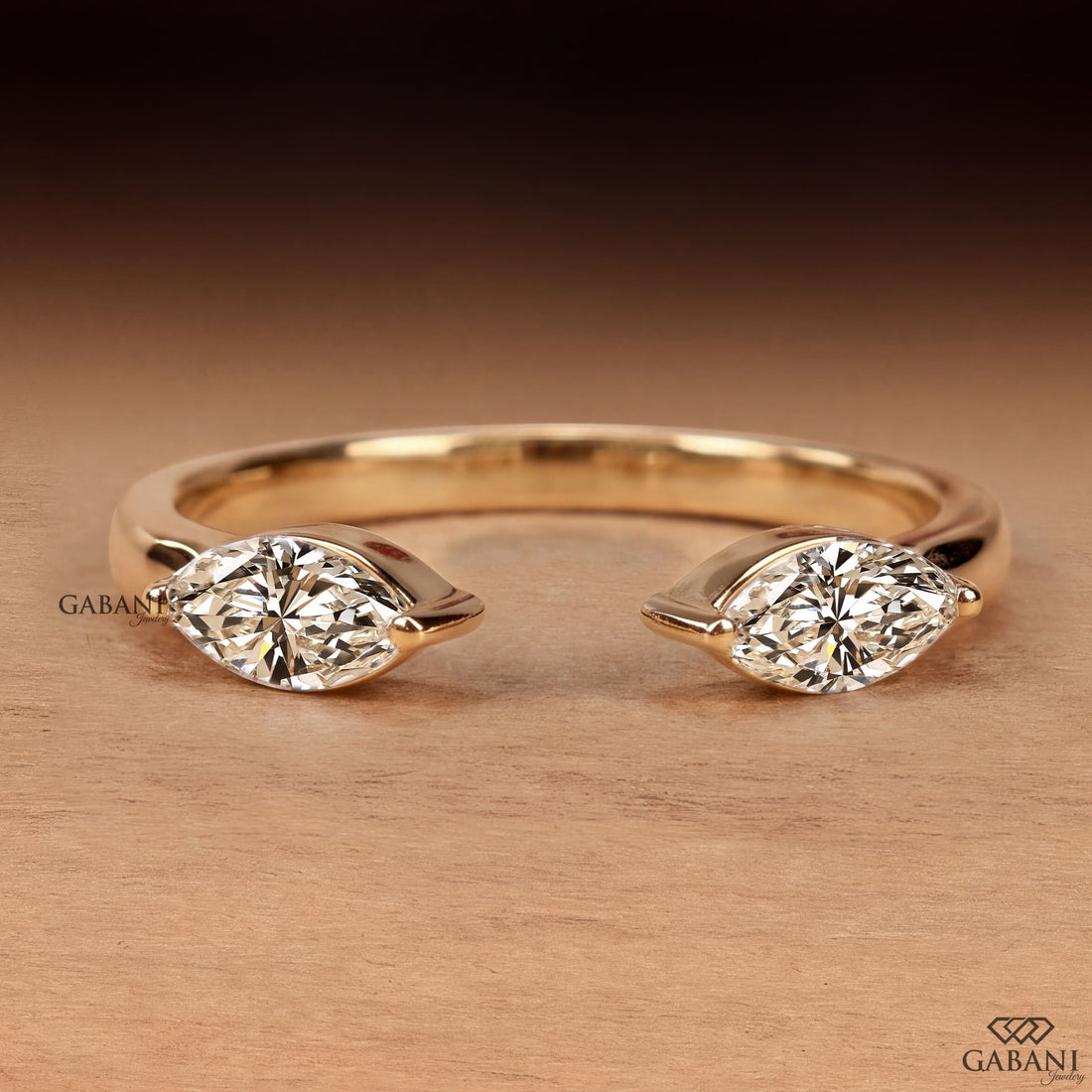 a marquise cut lab grown diamond open cuff ring in 14K yellow gold, featuring two horizontally set marquise diamonds in elegant half bezel settings with a modern minimalist design by Gabani Jewelry.