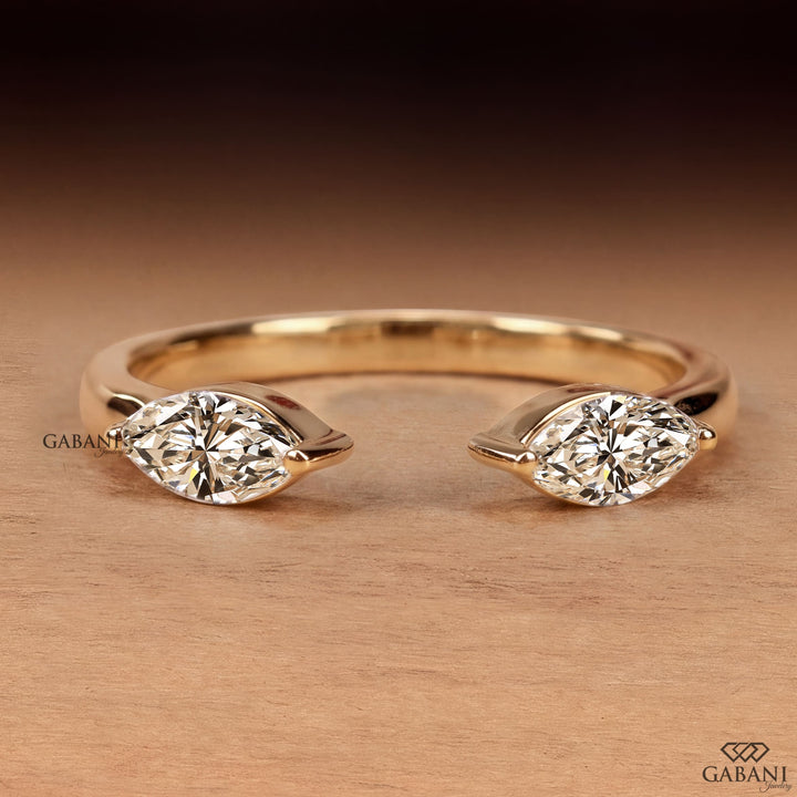 a marquise cut lab grown diamond open cuff ring in 14K yellow gold, featuring two horizontally set marquise diamonds in elegant half bezel settings with a modern minimalist design by Gabani Jewelry.