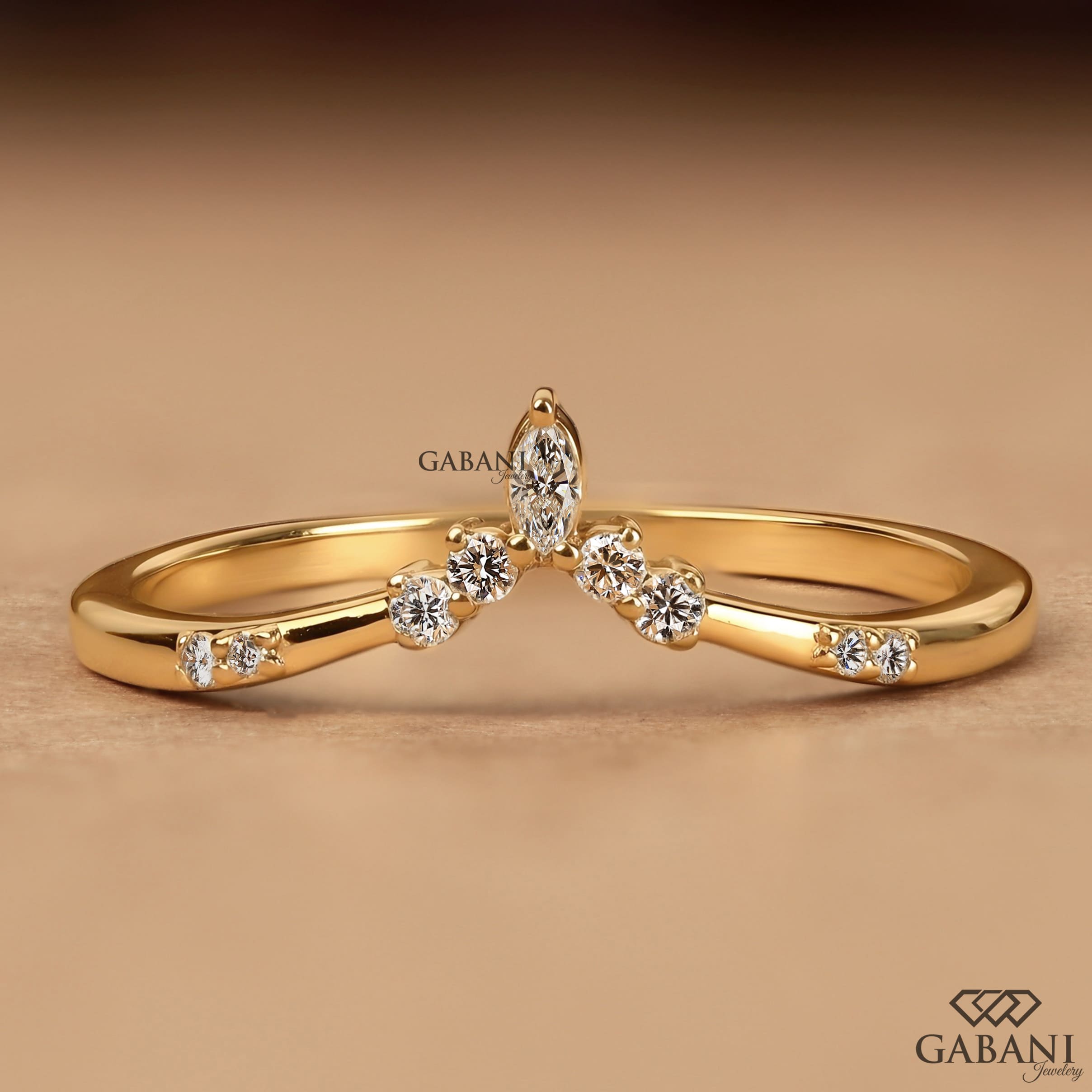 Marquise and round cut lab grown diamond curved wedding band in yellow gold with V shaped contour design for stacking with an engagement ring.