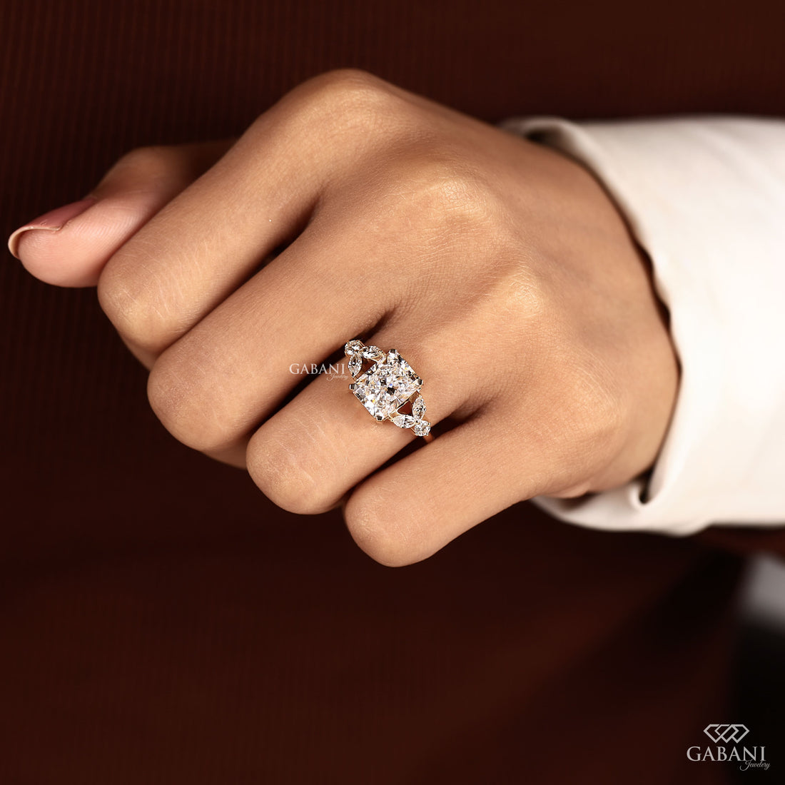 Radiant cut lab grown diamond engagement ring with marquise and round side diamond accents in a nature inspired gold setting.