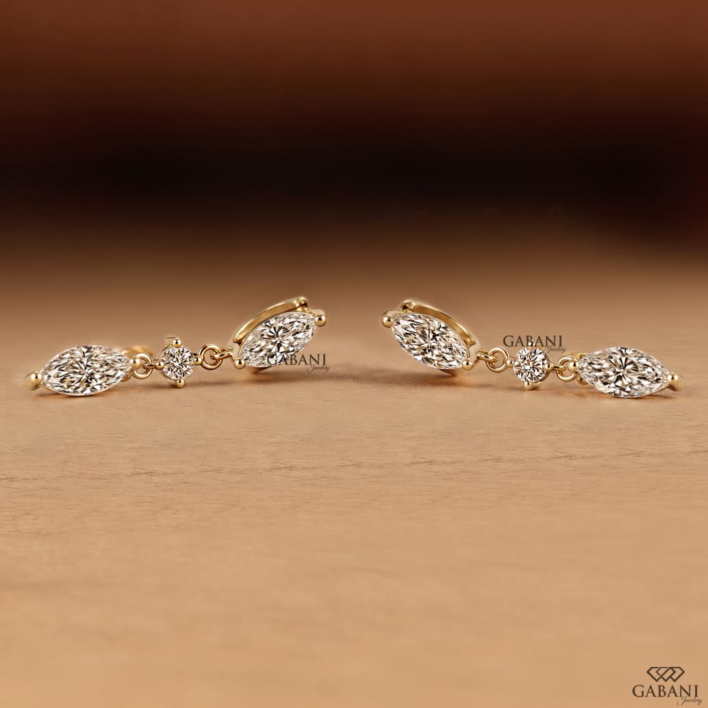 marquise and round cut lab grown diamond drop earrings in yellow gold, featuring two sparkling marquise diamonds connected by a round brilliant diamond on each earring, creating an elegant three-stone design by Gabani Jewelry.