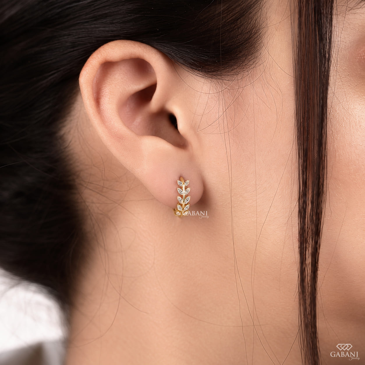 Marquise diamond leaf huggie earrings in yellow gold with a nature inspired vine design and marquise cut diamond leaves.