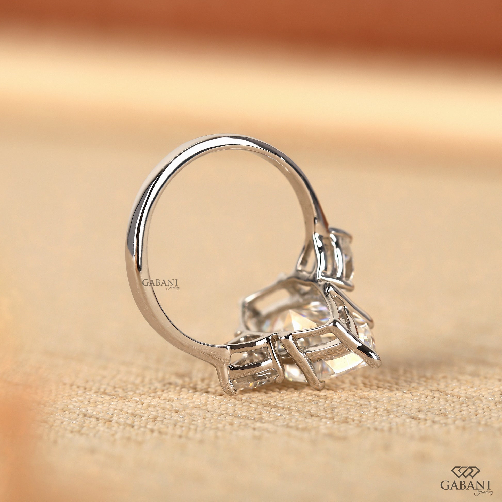 Elegant three stone lab diamond ring with marquise cut center and pear side stones in white gold