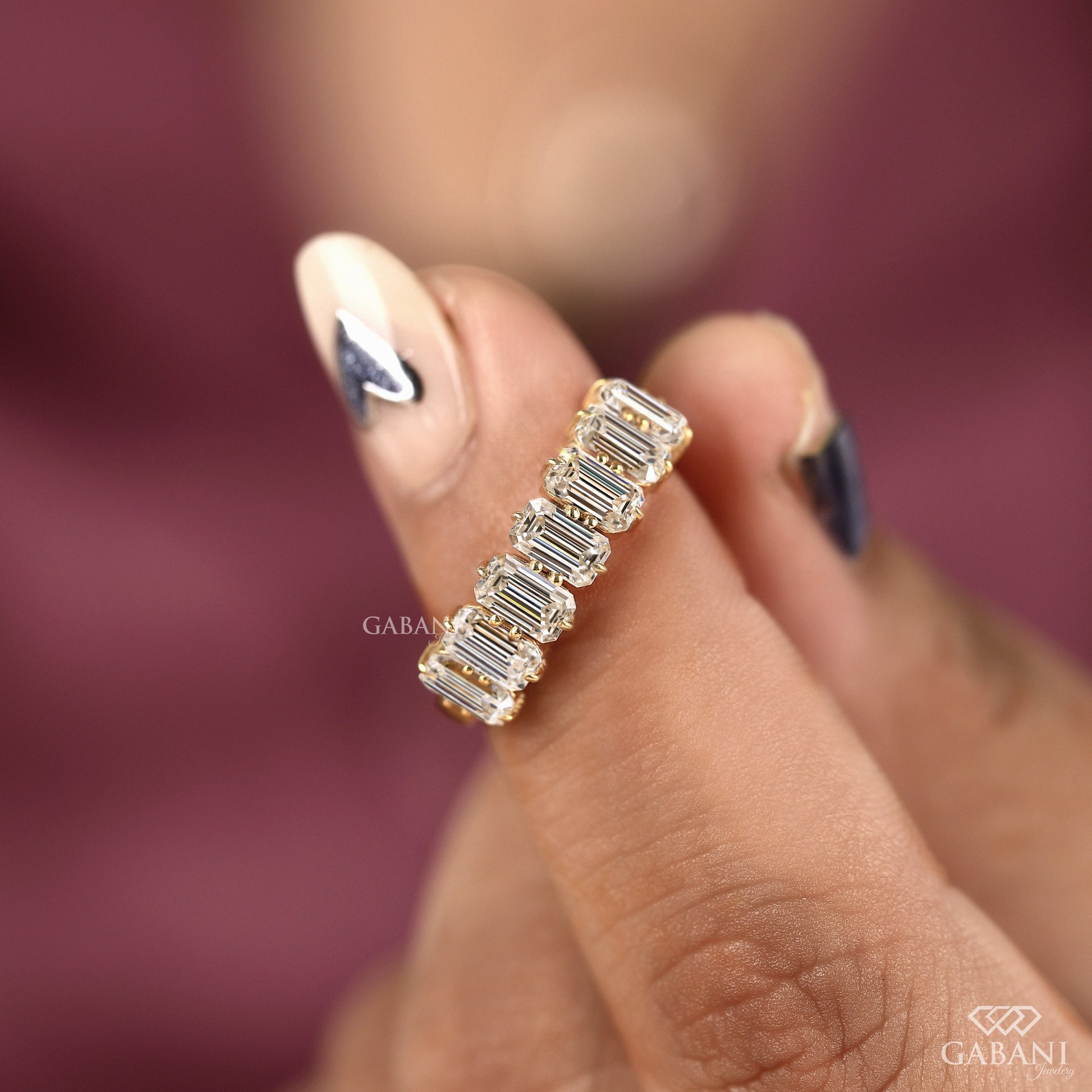 Yellow gold seven diamond band with emerald cut lab grown diamonds and balanced proportions