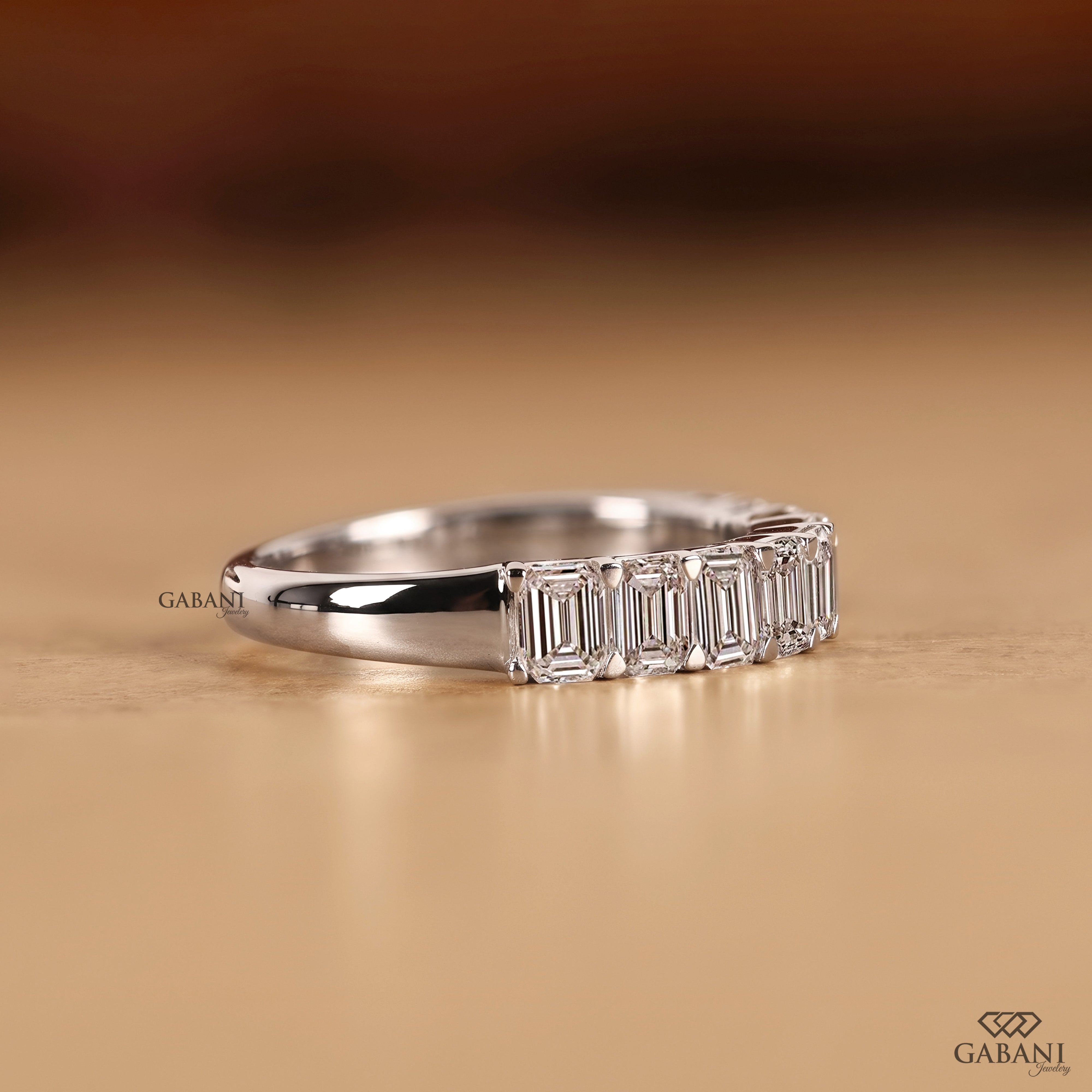 Side view of an emerald cut diamond wedding band featuring lab created diamonds in smooth white gold