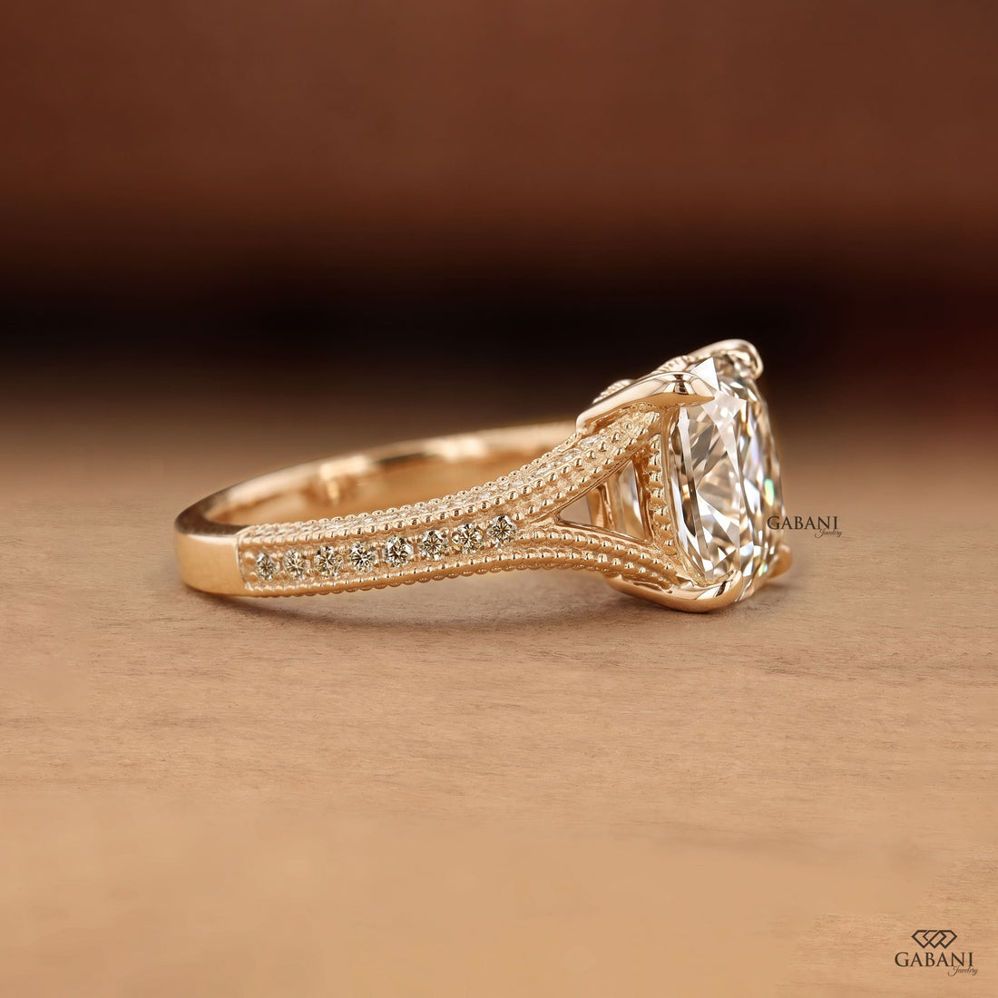 old mine cushion cut lab grown diamond engagement ring with split shank, round diamond accents and milgrain detail in 14K yellow gold.