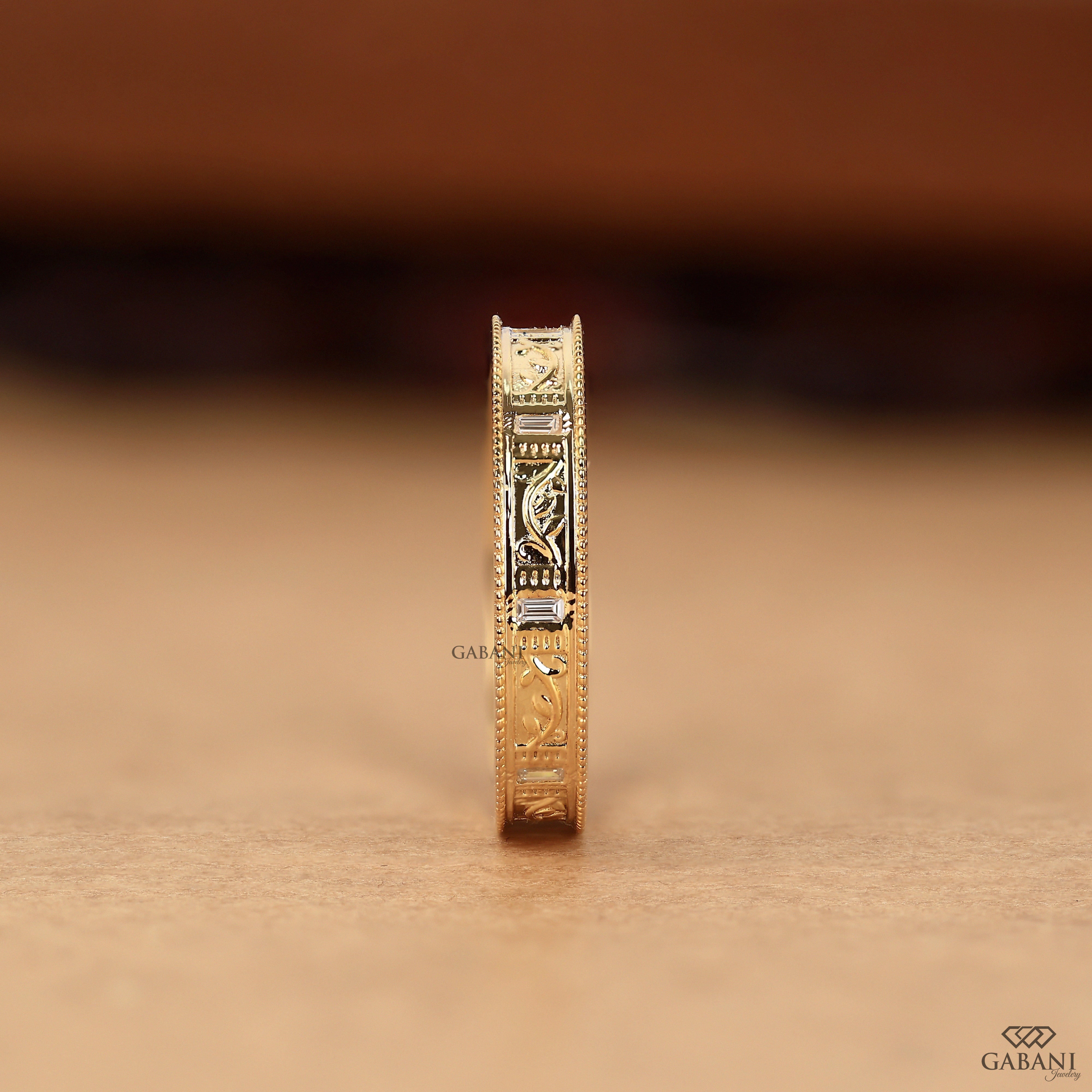 Baguette cut lab grown diamond wedding band with vintage floral engraving, milgrain edges, and polished yellow gold finish.