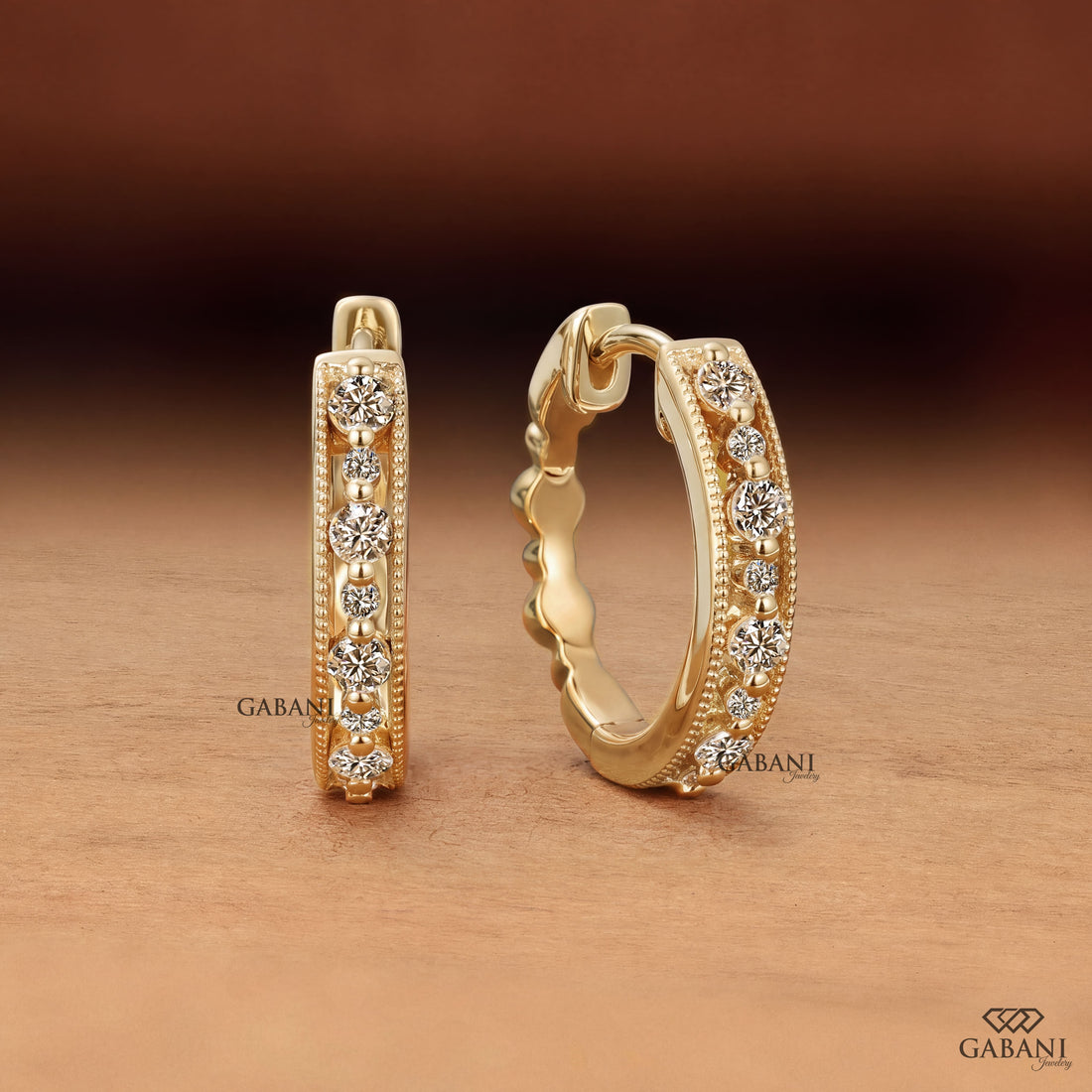 Round cut diamond milgrain hoop earrings in yellow gold with graduated diamonds and beaded edge detailing.
