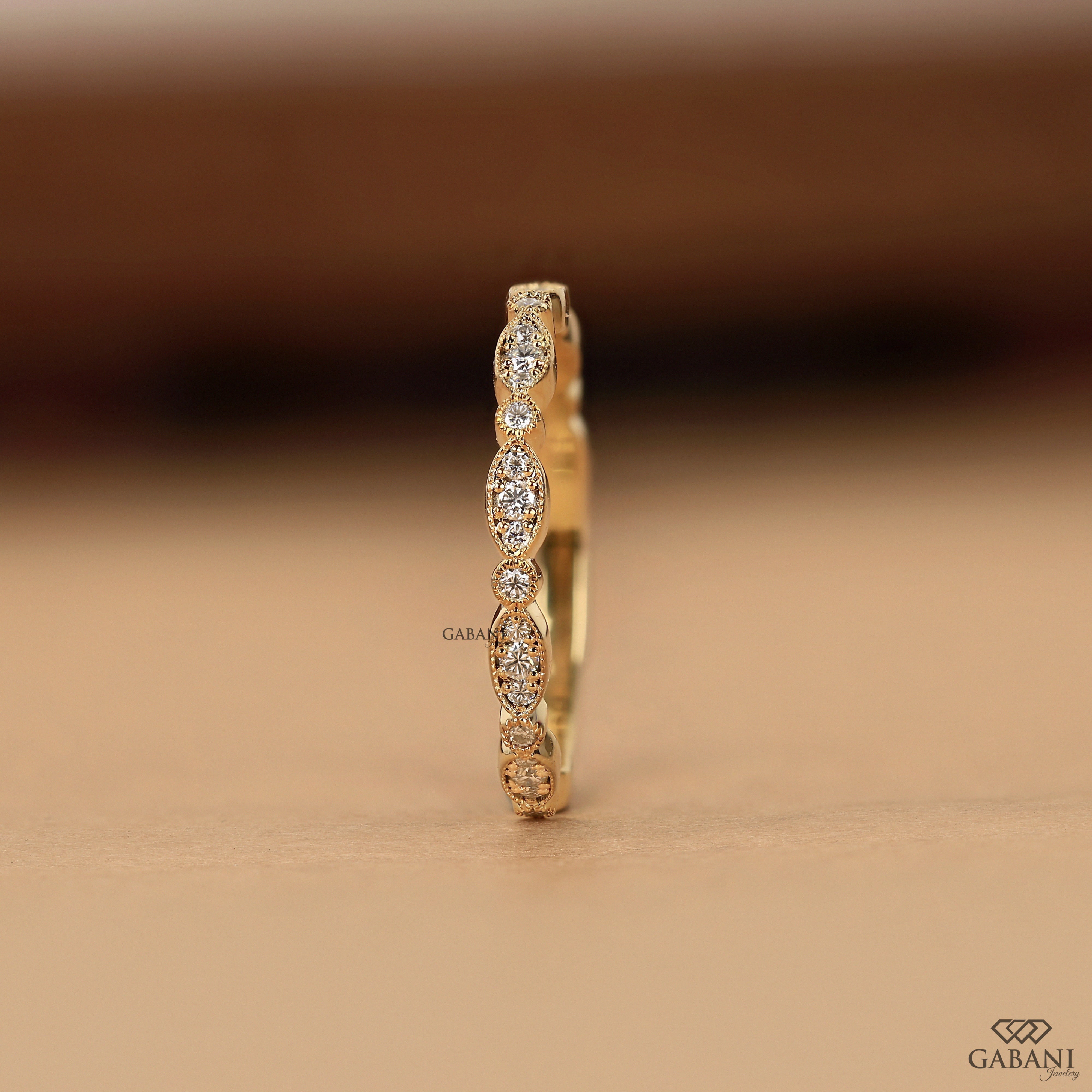 a round cut lab grown diamond wedding band in 14K yellow gold, featuring marquise-inspired diamond clusters, delicate milgrain detailing and a vintage design by Gabani Jewelry.