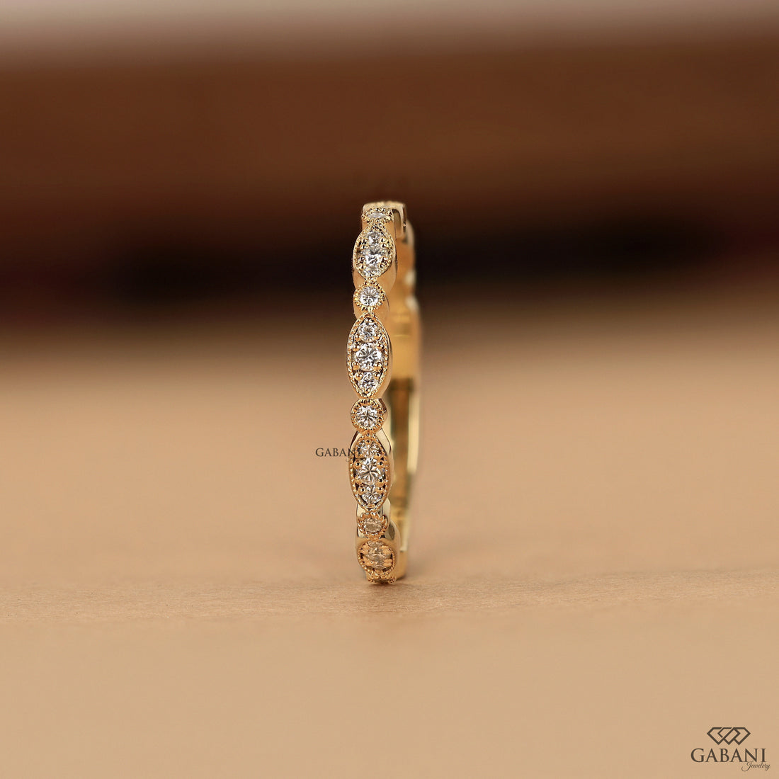 a round cut lab grown diamond wedding band in 14K yellow gold, featuring marquise-inspired diamond clusters, delicate milgrain detailing and a vintage design by Gabani Jewelry.