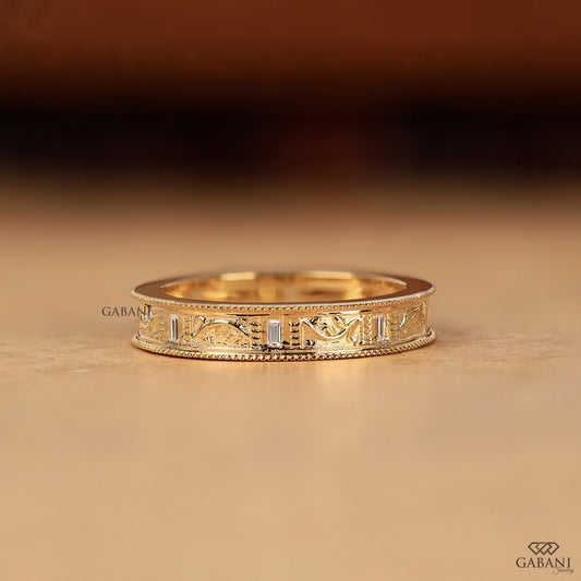 GABANIJEWELRY milgrain art deco wedding band on hand in yellow gold, leaf inspired design with engraved details and subtle diamond accents