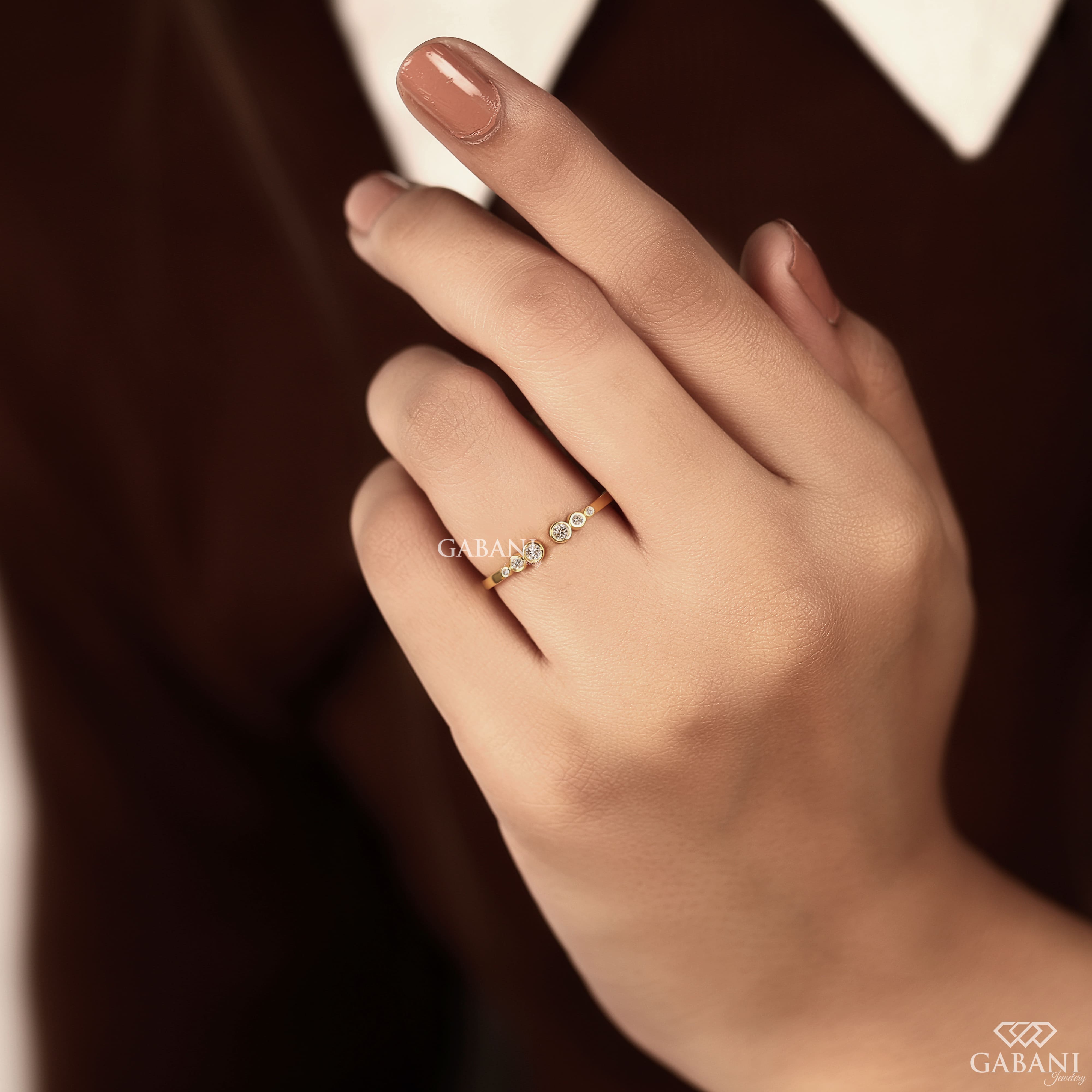 a round cut lab grown diamond open cuff band featuring six graduated bezel set diamonds in polished 14K yellow gold, a modern minimalist diamond wedding band by Gabani Jewelry.