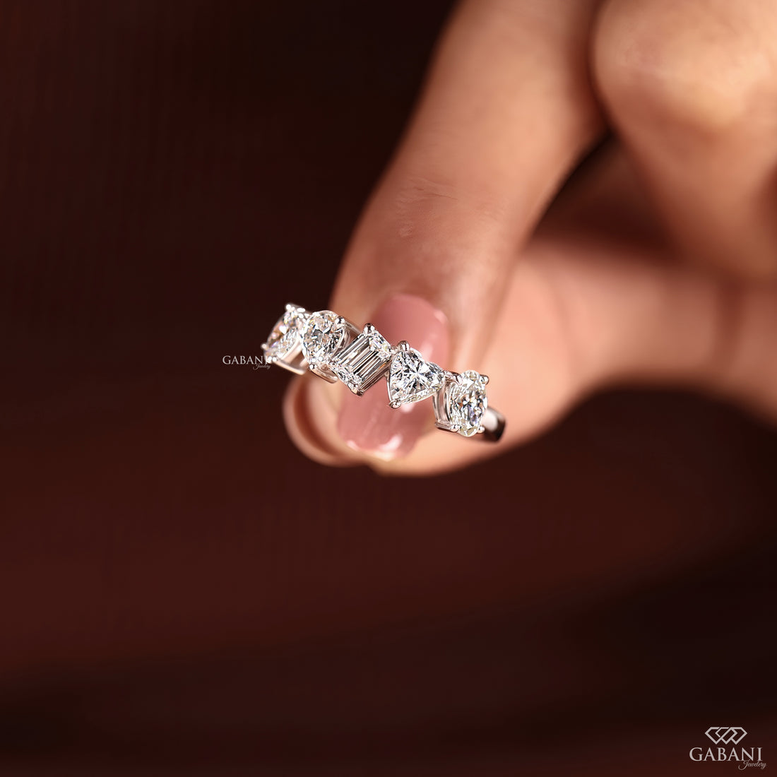 Hand holding multi shape lab grown diamond band in 14K white gold
