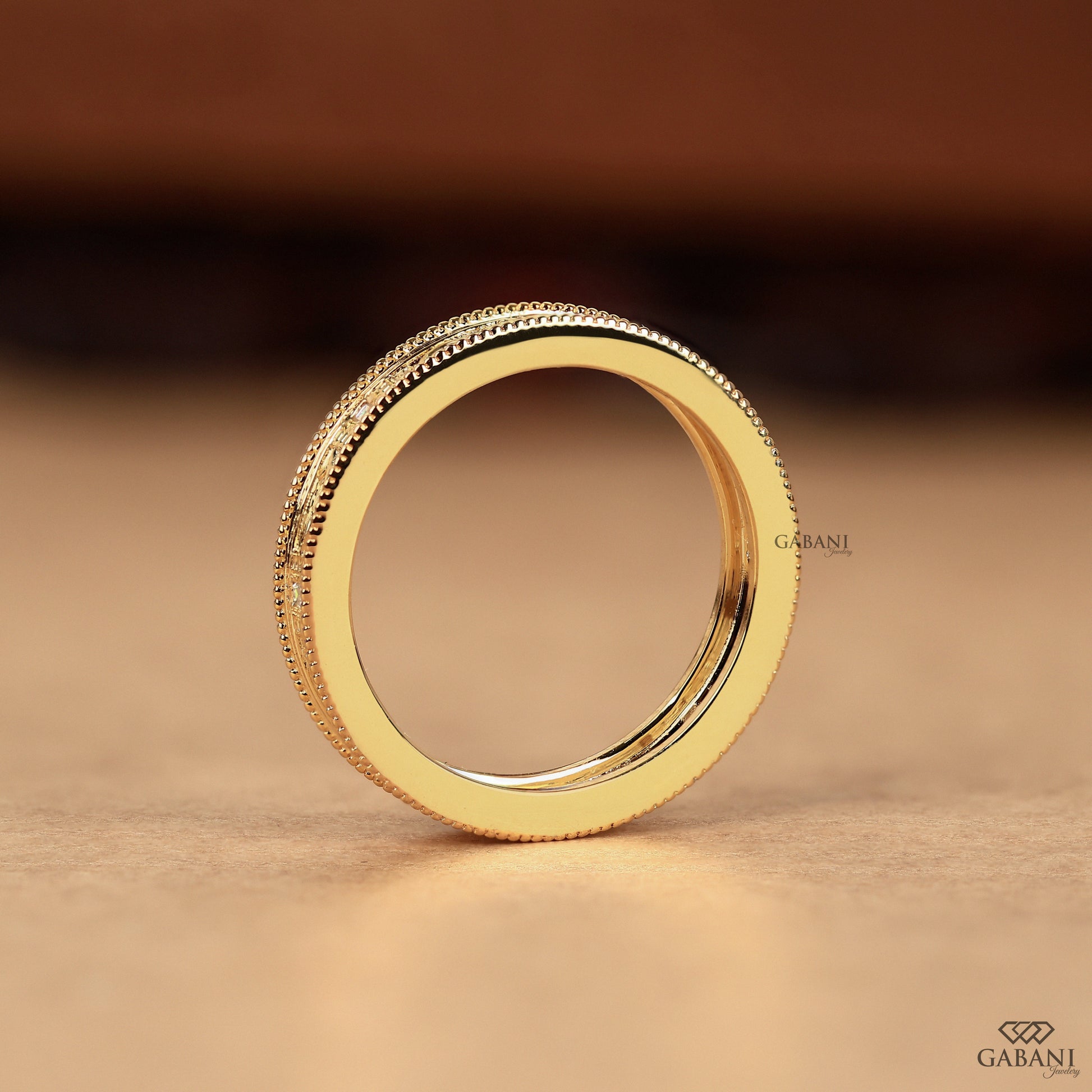 Side view of yellow gold milgrain band highlighting engraved leaf pattern and slightly raised structure with smooth balanced profile