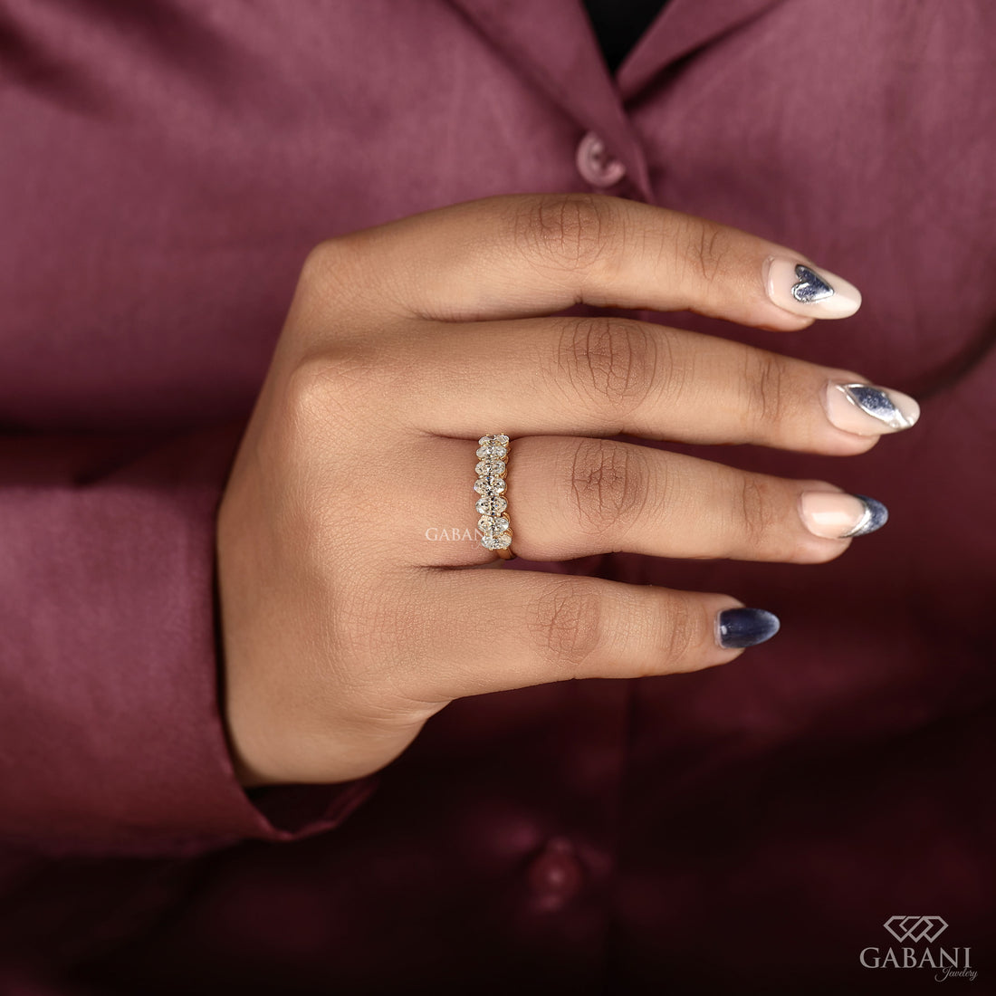 seven oval cut lab grown diamonds arranged in a prong set half eternity wedding band with polished 14K yellow gold.