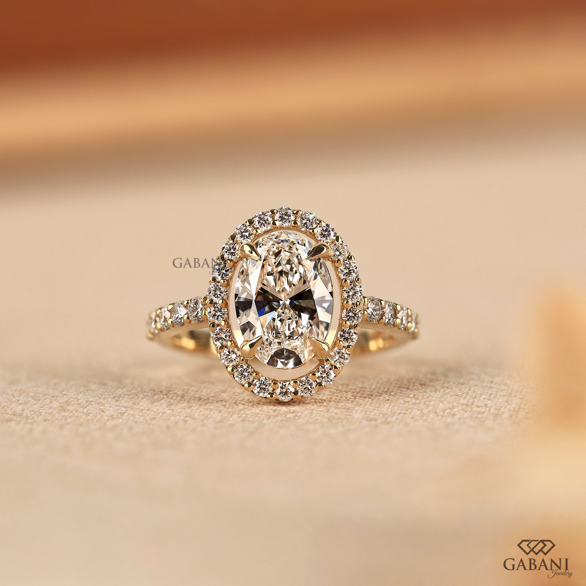 Oval cut lab grown diamond ring with pave halo in yellow gold