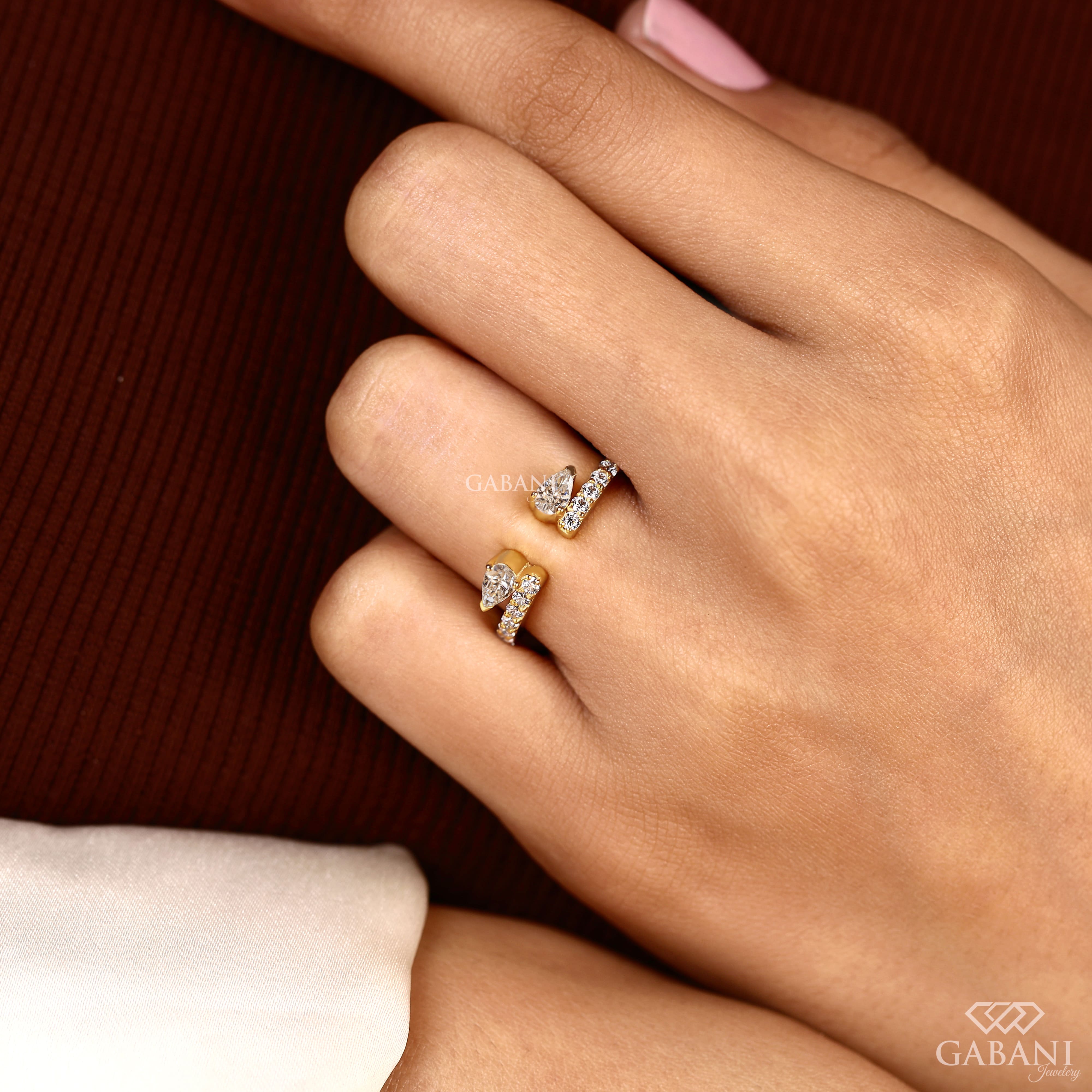 pear cut lab grown diamond open cuff ring showing the partial bezel settings, open ends and polished yellow gold band.