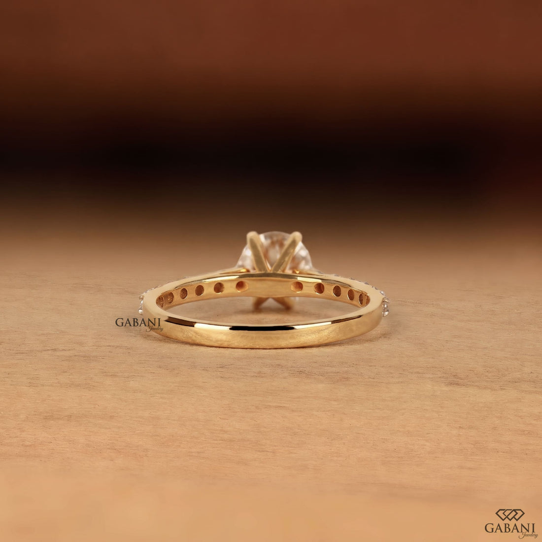 Round cut lab grown diamond solitaire engagement ring in yellow gold featuring a classic six prong setting and pavé diamond band.