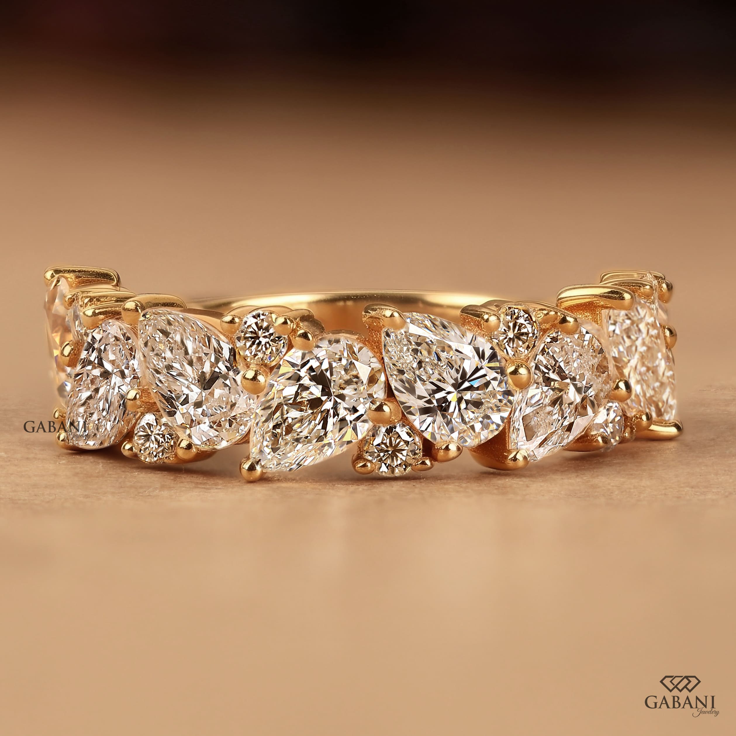 Pear and round lab grown diamond half eternity wedding band in yellow gold with alternating prong set diamond design.