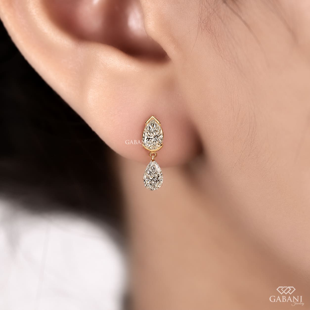 pear cut lab grown diamond drop earrings in yellow gold, featuring two sparkling pear-shaped diamonds on each earring in an elegant double teardrop design by Gabani Jewelry.