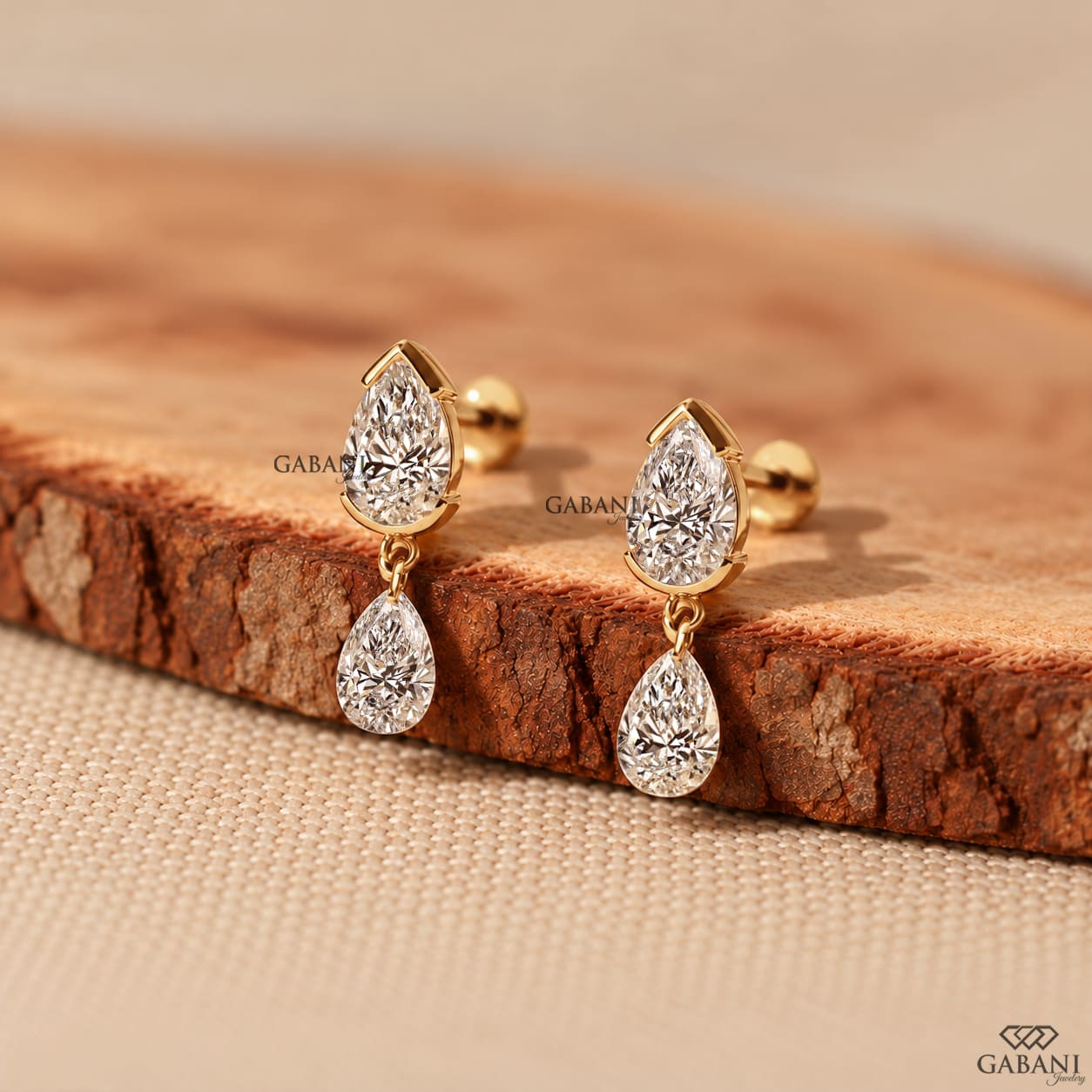 pear cut lab grown diamond drop earrings in yellow gold, featuring two sparkling pear-shaped diamonds on each earring in an elegant double teardrop design by Gabani Jewelry.