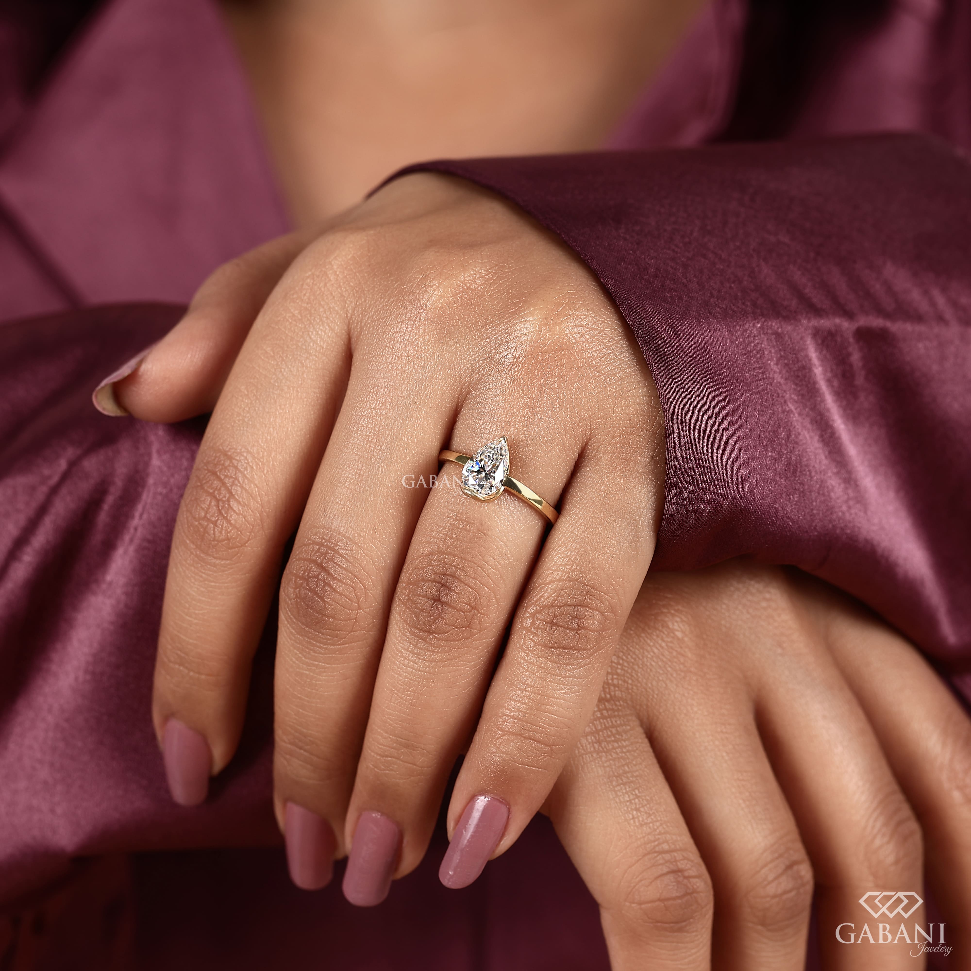 9x6mm pear cut lab grown diamond solitaire engagement ring with modern half bezel setting in polished 14K yellow gold.