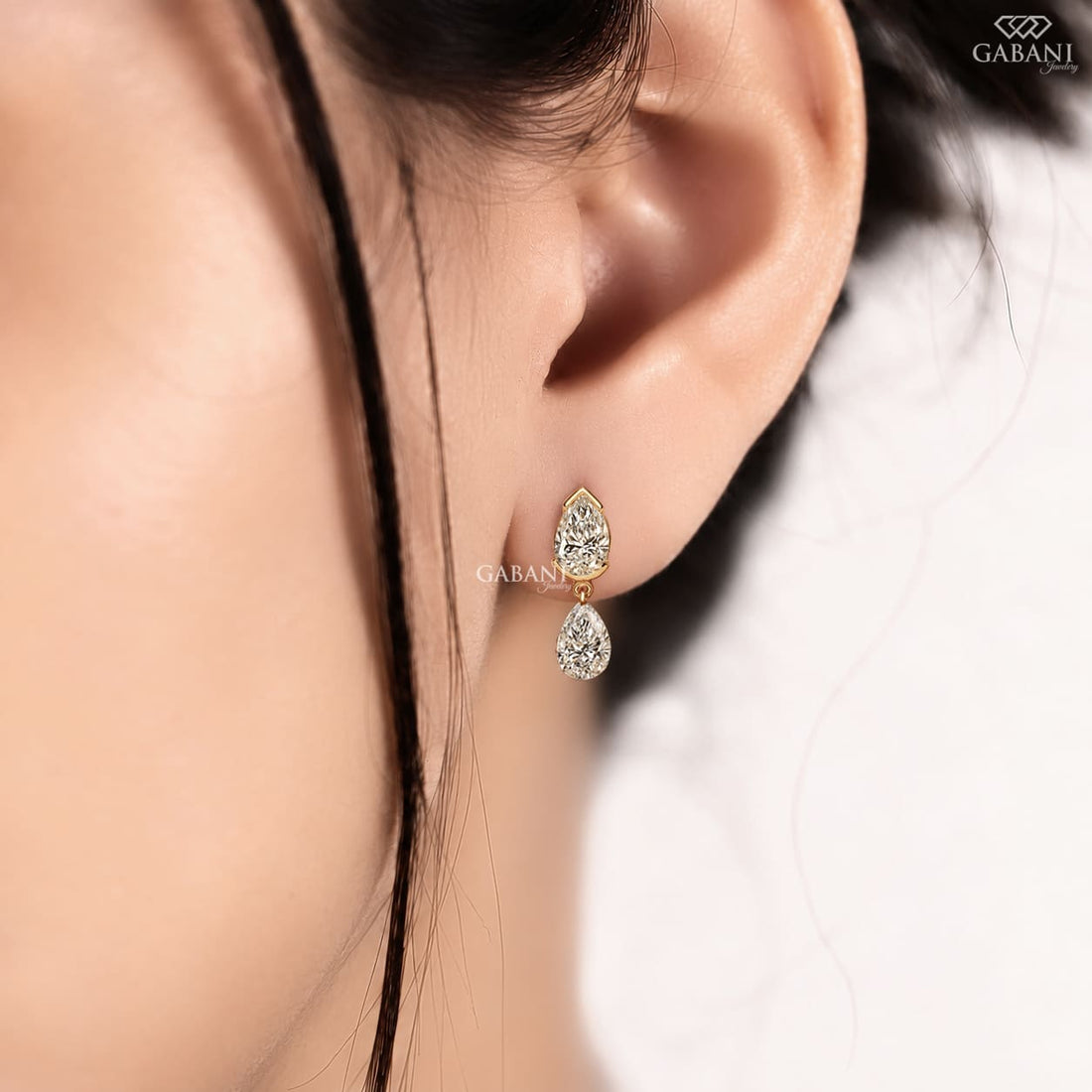 pear cut lab grown diamond drop earrings in yellow gold, featuring two sparkling pear-shaped diamonds on each earring in an elegant double teardrop design by Gabani Jewelry.