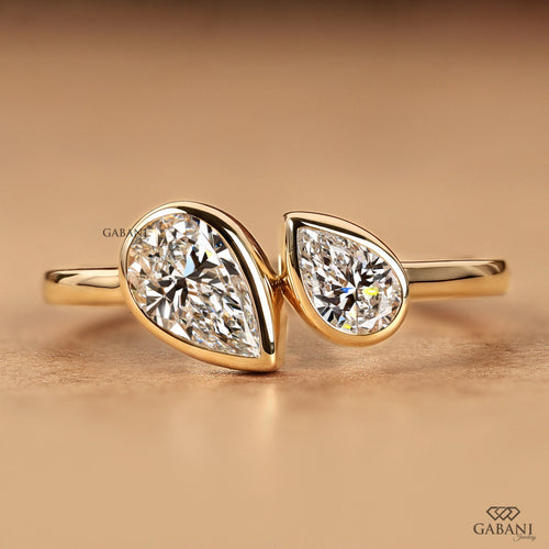 Front view of a pear cut lab grown diamond Toi et Moi engagement ring with two bezel set diamonds in a timeless two stone design