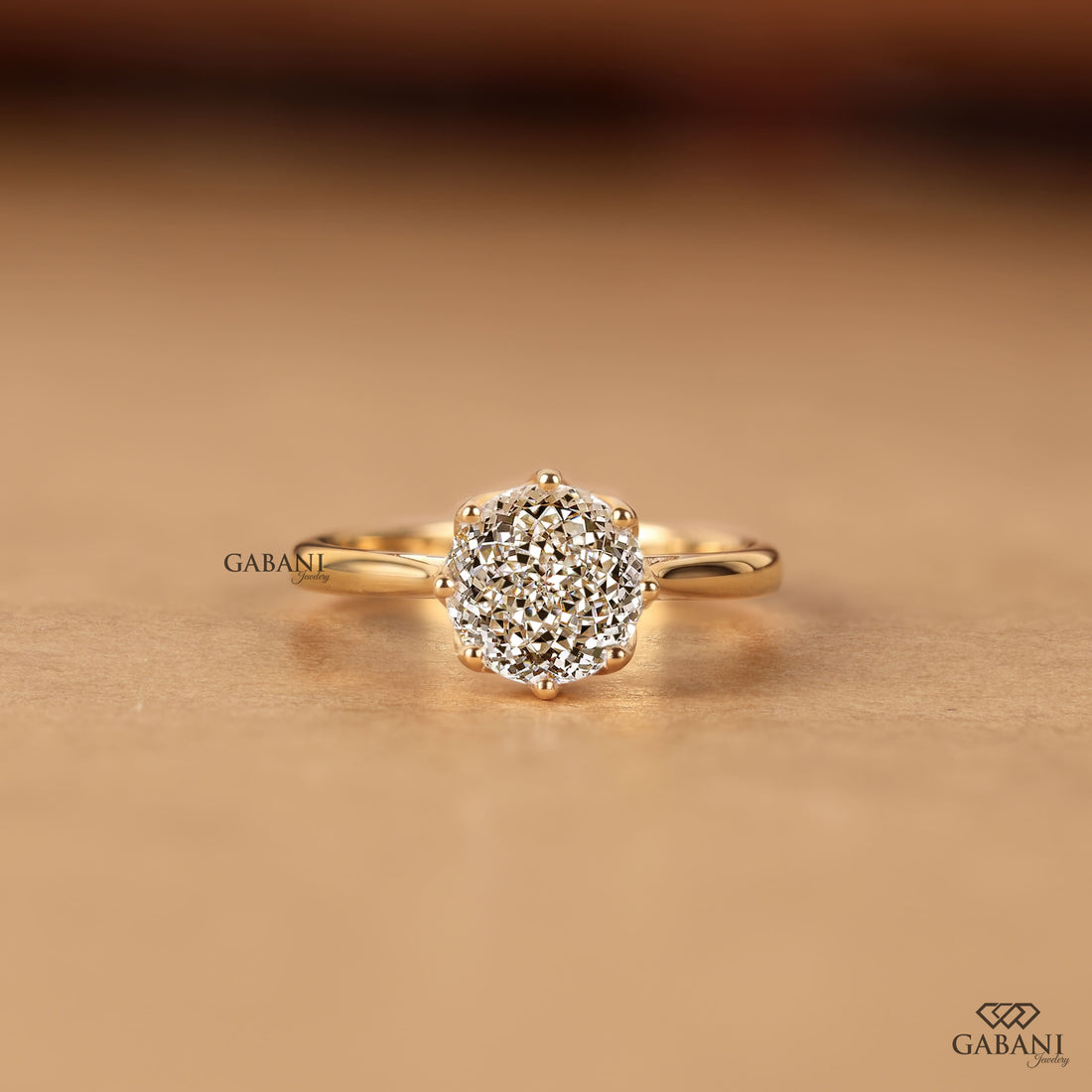 Shop a round Portuguese cut lab grown diamond solitaire engagement ring with a six-prong floral basket and polished yellow gold band.