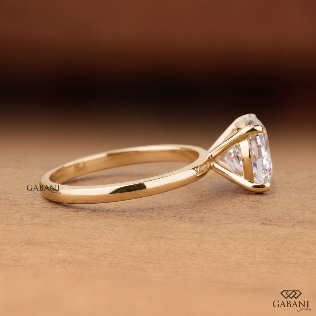 Round cut lab grown diamond solitaire engagement ring with four-prong setting and polished yellow gold band.