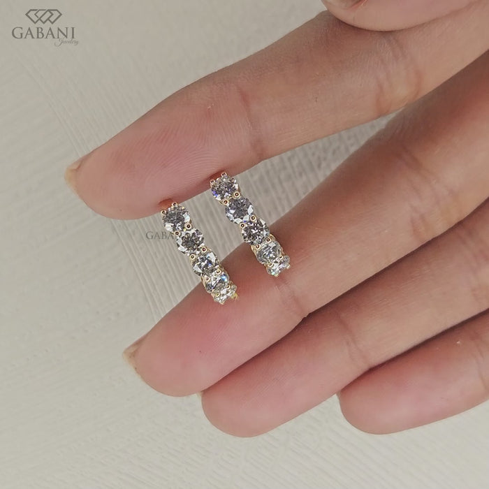 Yellow gold hoop earrings featuring round cut lab grown diamonds in a huggie style