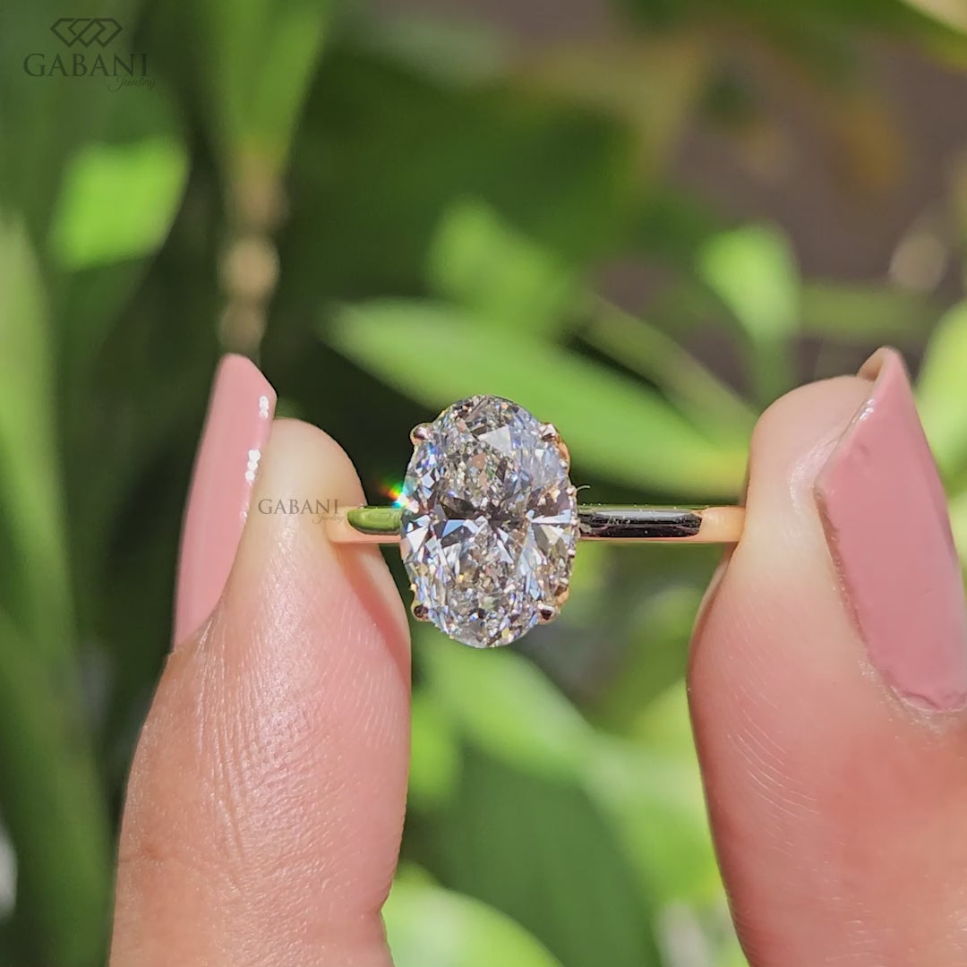 Oval diamond solitaire engagement ring shown as a bridal ring with a graceful hidden halo and tulip setting, handcrafted to celebrate life's most meaningful moments.