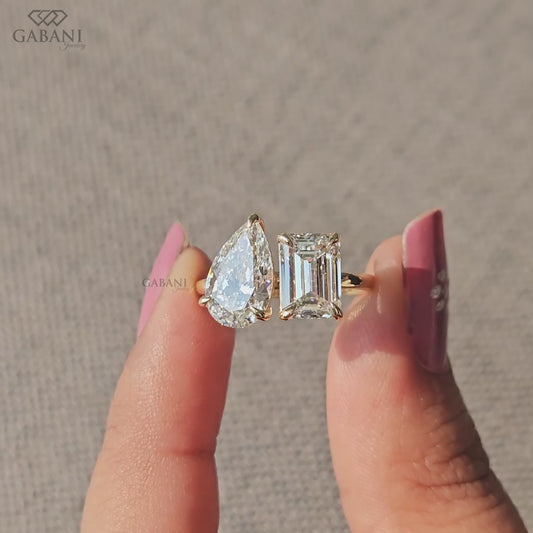 Two diamond Toi et Moi ring featuring emerald cut and pear cut lab grown diamonds in polished 14K yellow gold