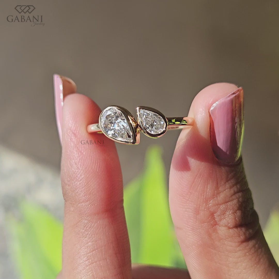 Front view of a pear cut lab grown diamond Toi et Moi engagement ring with two bezel set diamonds in a timeless two stone design