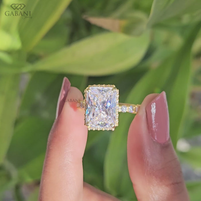 Radiant cut lab grown diamond engagement ring with hidden halo, round and baguette side diamonds, and polished gold band.
