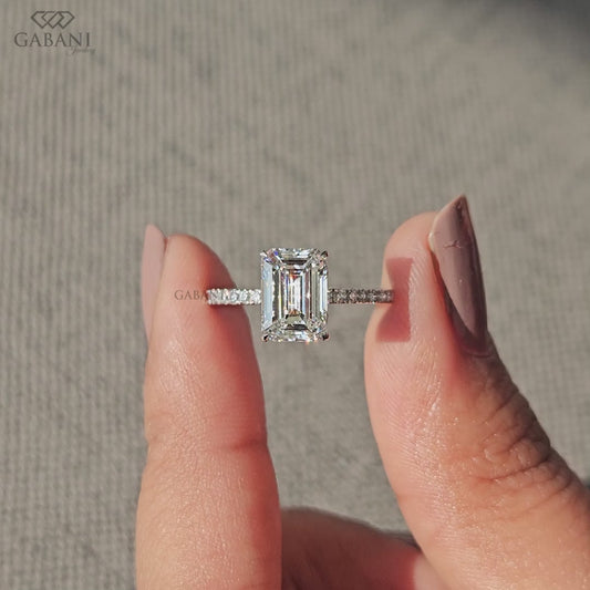 minimal solitaire engagement ring with emerald cut lab grown diamond and thin french pave band in white gold