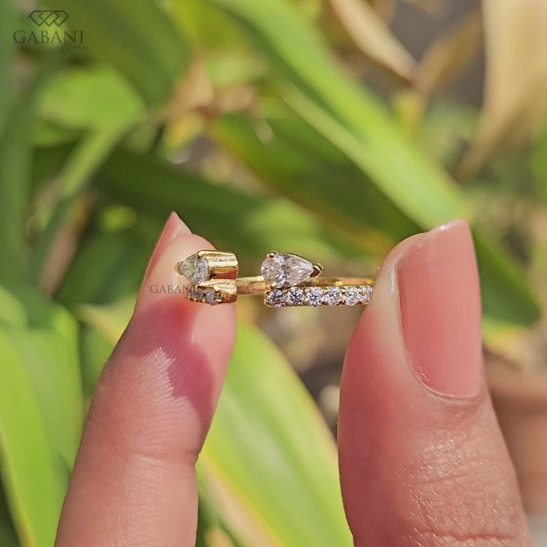 pear cut lab grown diamond open cuff ring showing the partial bezel settings, open ends and polished yellow gold band.