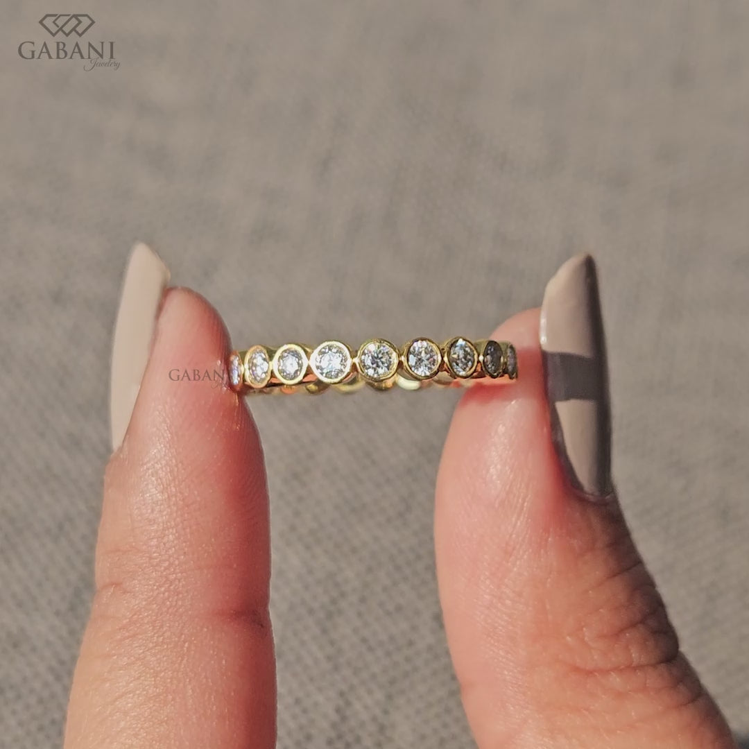 Round diamond bezel set wedding band in yellow gold
