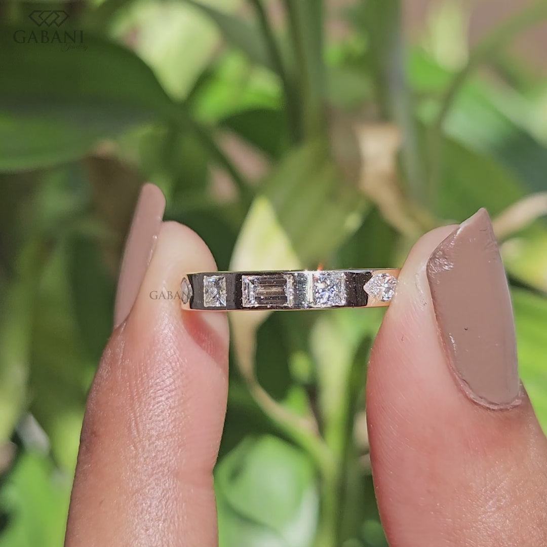 Solid 14K yellow gold flush setting wedding band with princess, baguette, round, and marquise lab grown diamonds shown as a modern matching wedding band.