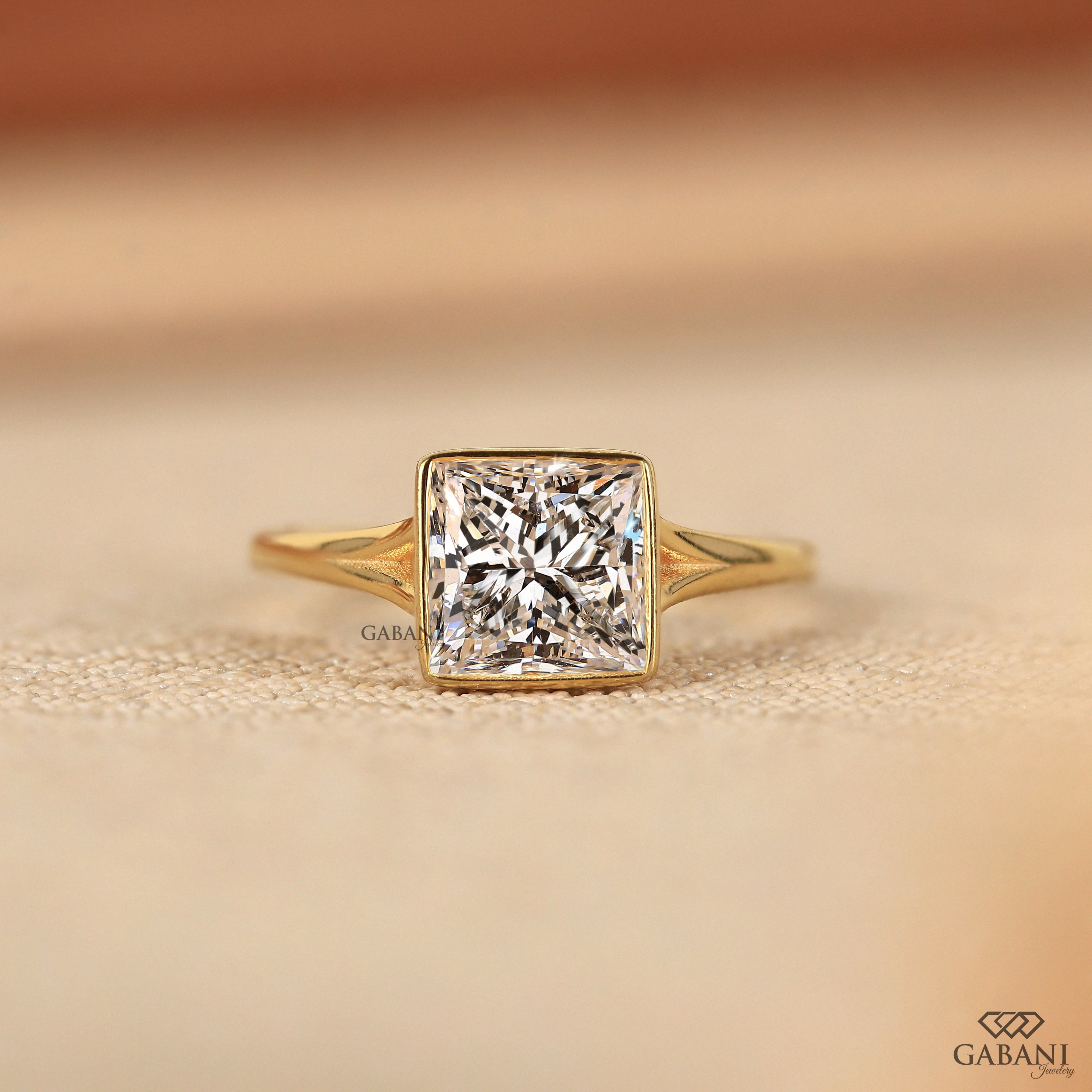 princess cut lab grown diamond engagement ring in 18K yellow gold with a full bezel setting and tapered polished band.