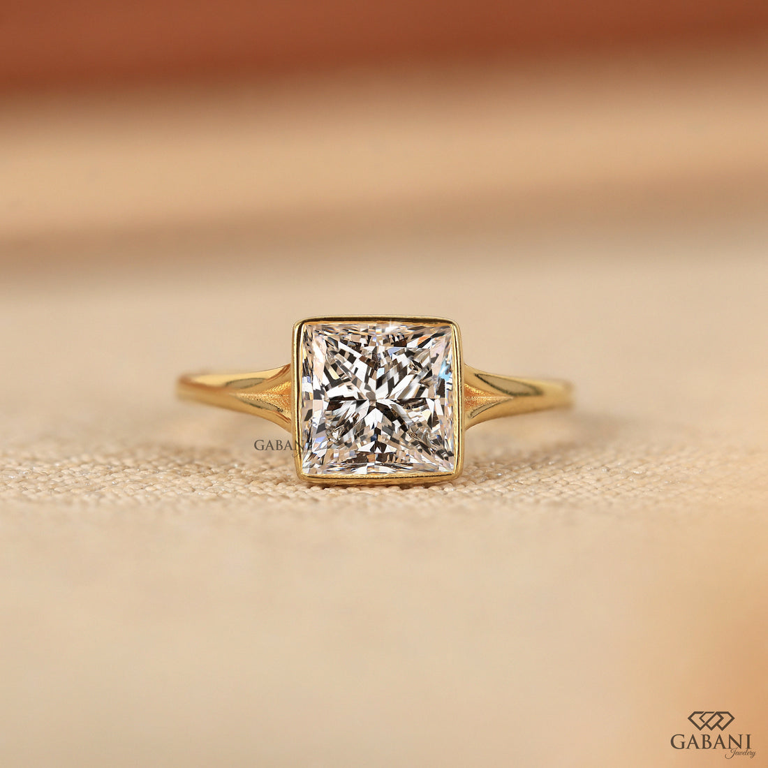 princess cut lab grown diamond engagement ring in 18K yellow gold with a full bezel setting and tapered polished band.
