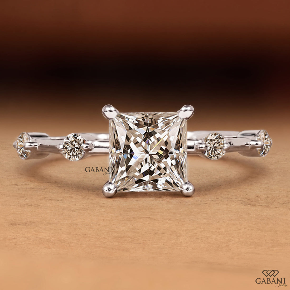 Princess cut lab grown diamond engagement ring in white gold with a four prong center setting and spaced round diamond side stones along the polished band.