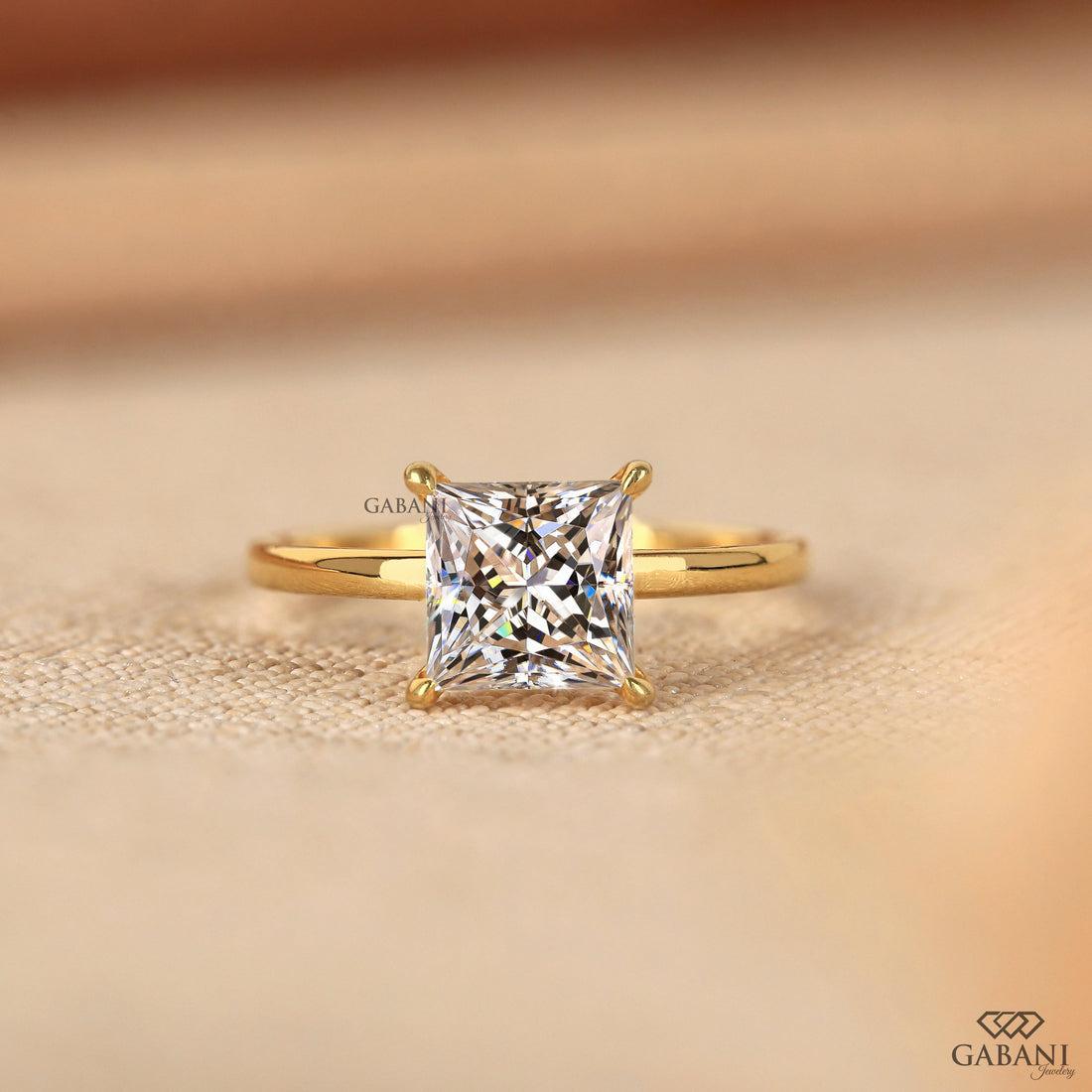 Side view of princess cut lab grown diamond solitaire engagement ring in 18K yellow gold with a classic four prong setting and polished band.