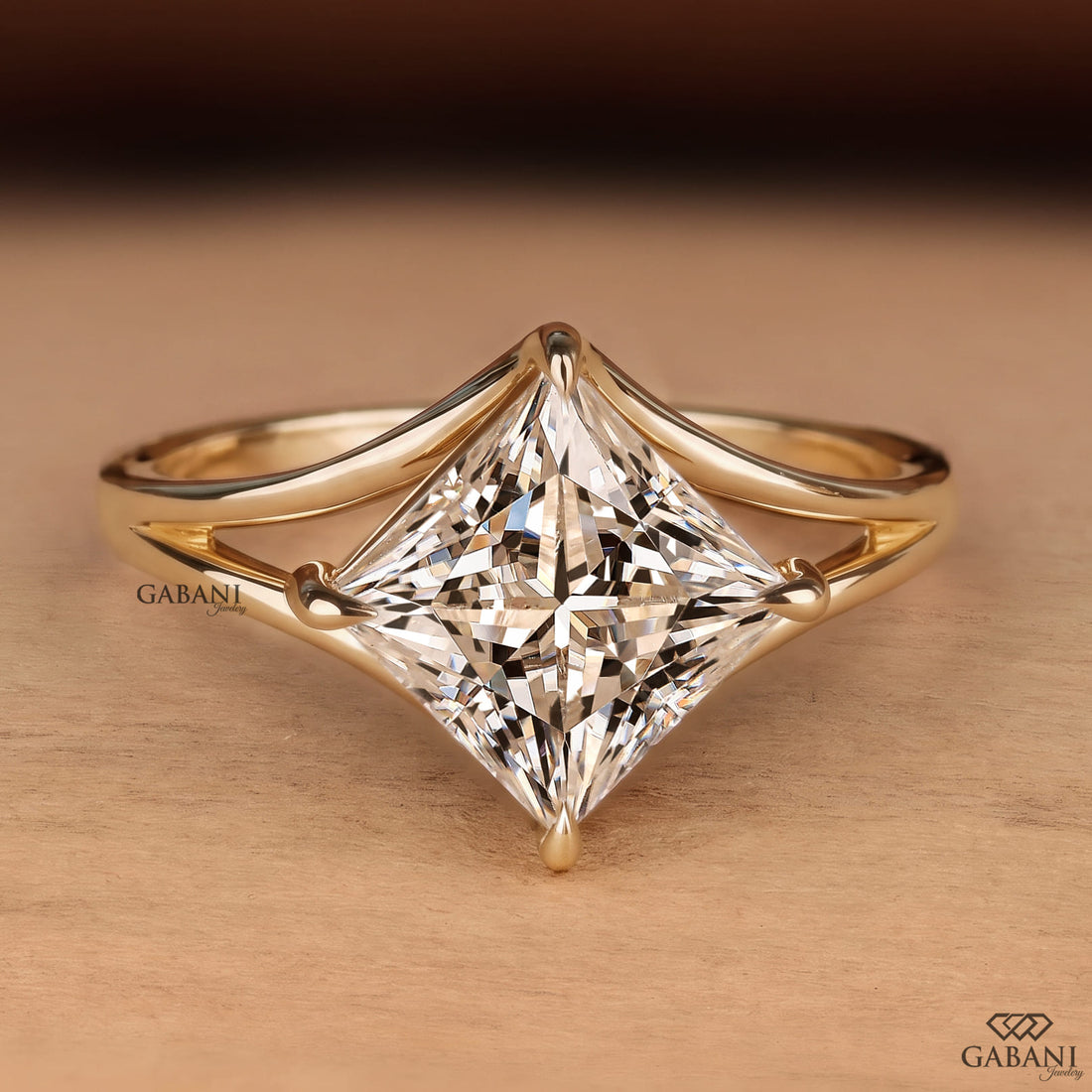 Princess cut lab grown diamond engagement ring in yellow gold featuring a kite set center stone, four prong setting, and modern open split shank design.