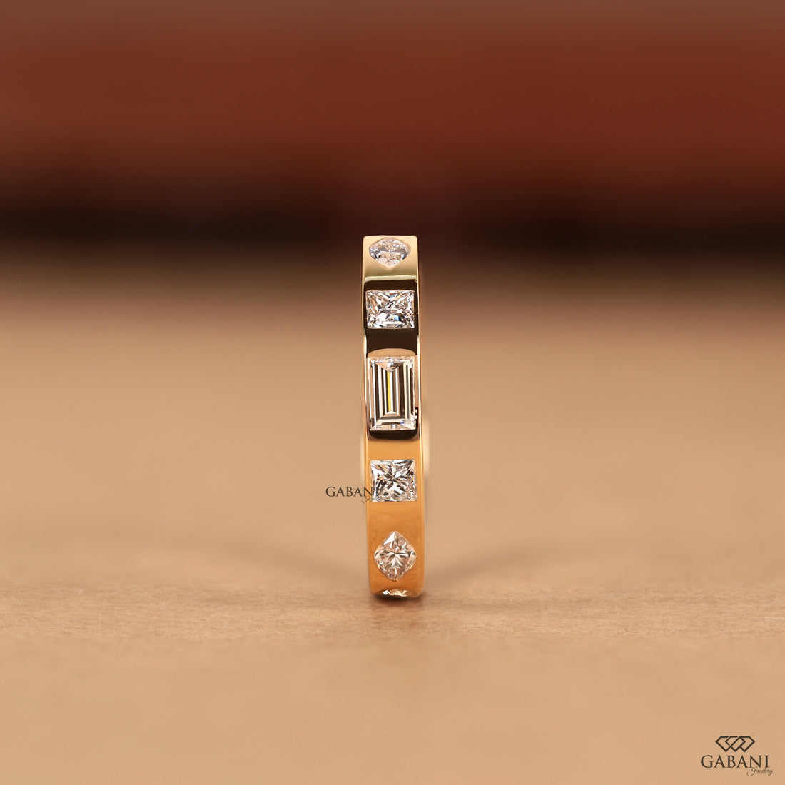 Solid 14K yellow gold flush set wedding ring featuring princess, baguette, round, and marquise lab grown diamonds with a low profile flat band.