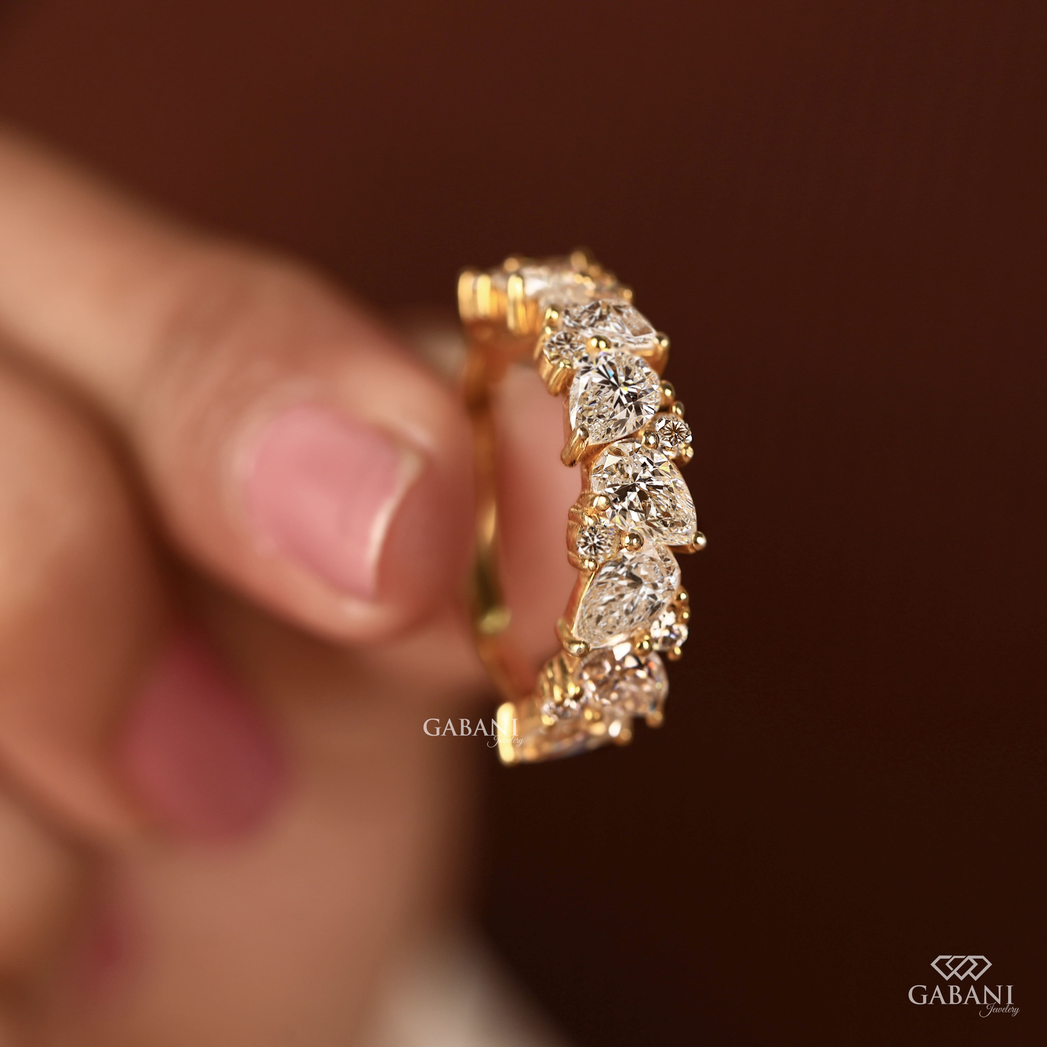 Pear and round lab grown diamond half eternity wedding band in yellow gold with alternating prong set diamond design.